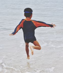 Full length of boy jumping on beach