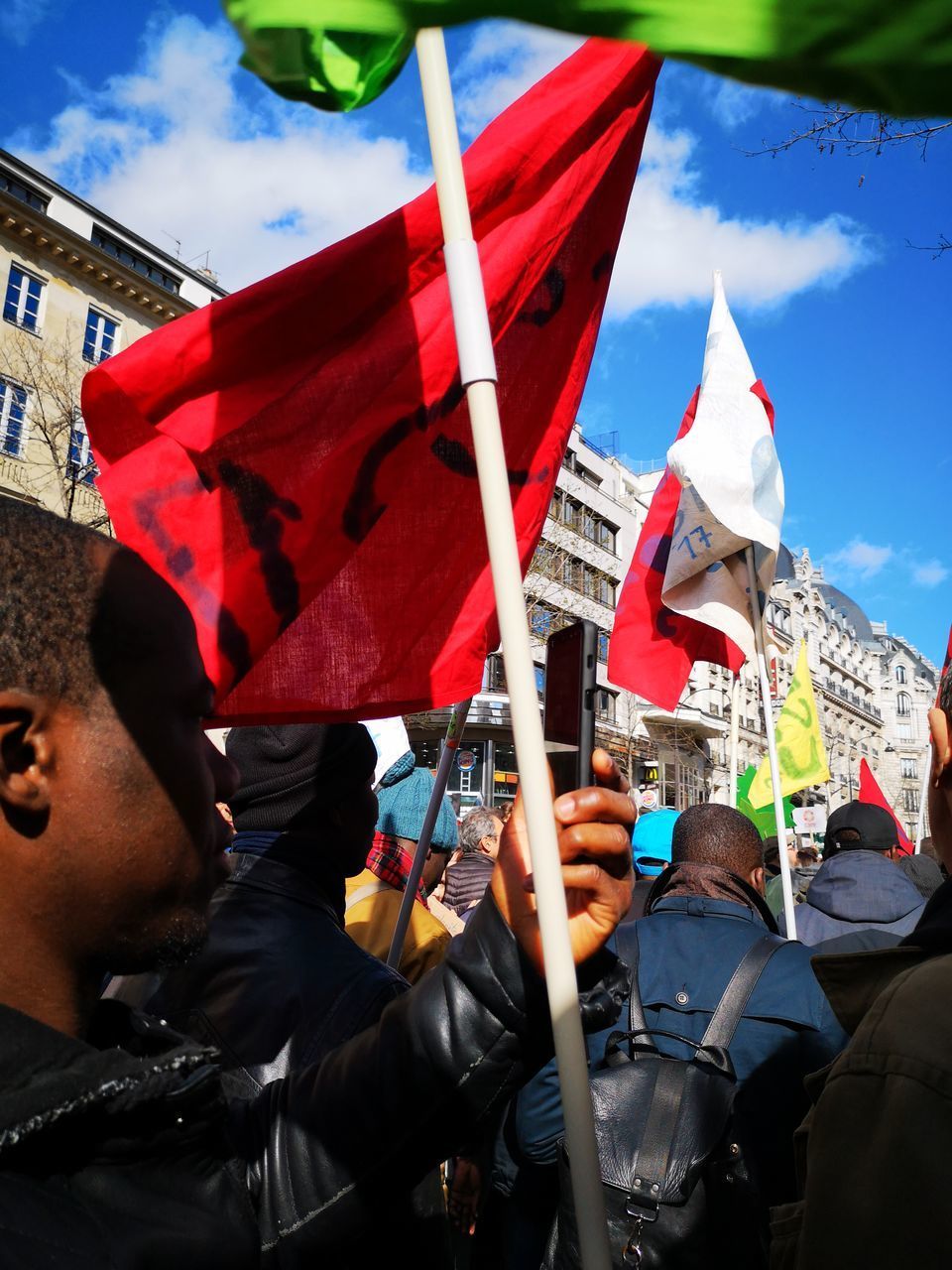 PEOPLE HOLDING FLAG AGAINST CITY BUILDINGS