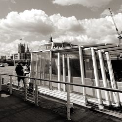 People standing on railing against sky