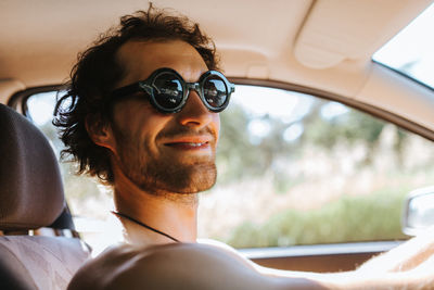 Close-up of smiling man sitting in car