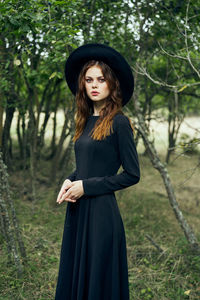 Portrait of young woman standing in forest