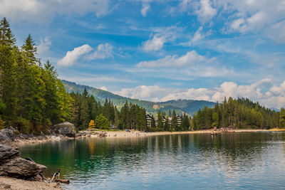 Scenic view of lake by trees against sky