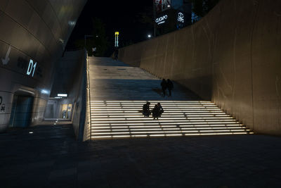 People walking on footpath at night