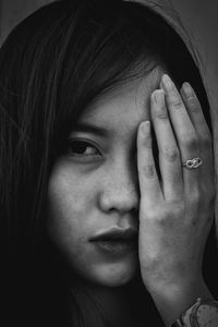 Close-up portrait of woman covering eye