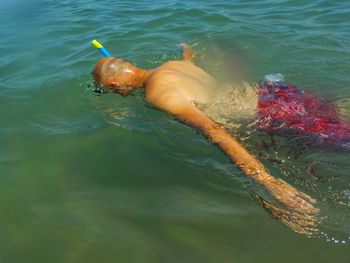 Shirtless man swimming in sea