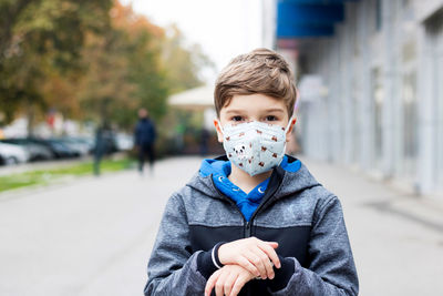 Portrait of a kid with kn95 face mask in the city during covid-19 pandemic.