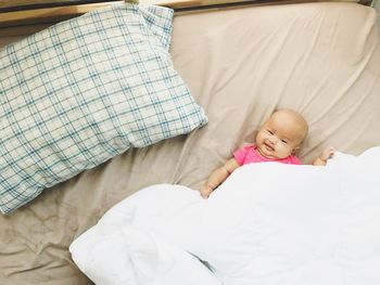 High angle view of baby lying on bed at home