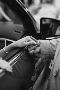 People holding hands by car