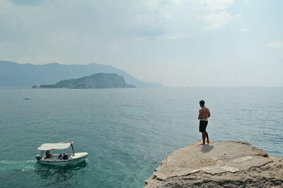 Rear view of man overlooking sea