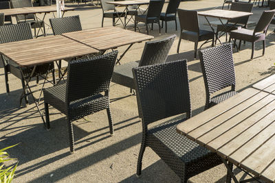 High angle view of empty chairs and tables at sidewalk cafe