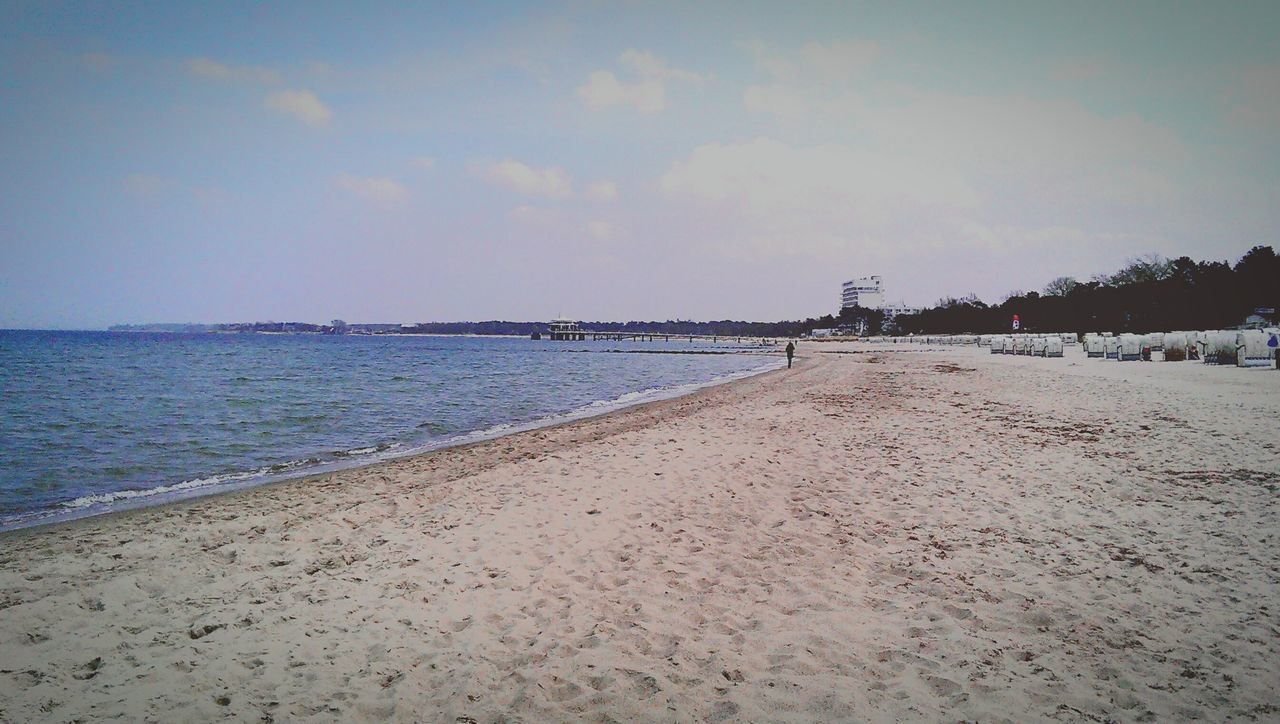 sea, beach, water, shore, sand, sky, horizon over water, tranquil scene, tranquility, scenics, beauty in nature, nature, coastline, incidental people, idyllic, built structure, outdoors, cloud - sky, calm, day