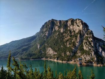 Scenic view of lake and mountains against clear blue sky