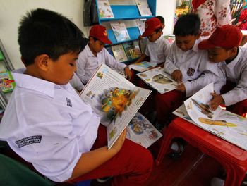 Rear view of people sitting on table