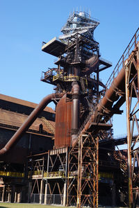 Low angle view of industry against sky in city