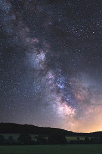 Silhouette landscape against star field at night