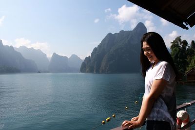 Young woman with arms raised against mountains