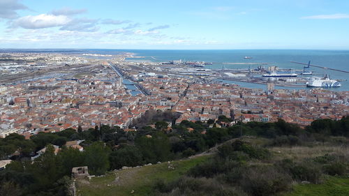 High angle view of townscape by sea against sky