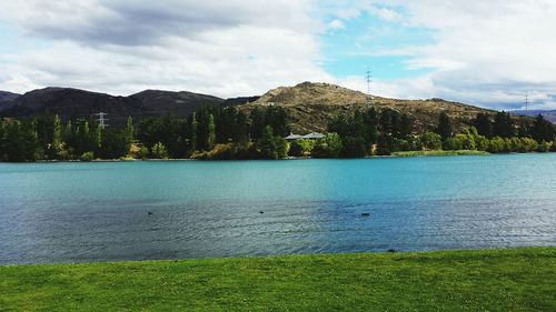 Scenic view of lake and mountains against cloudy sky