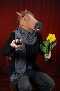 The man in the horse mask with flowers and whiskey 