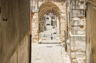 People in alley amidst buildings