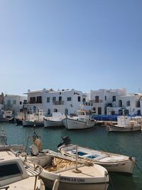 Boats moored in harbor against buildings in city