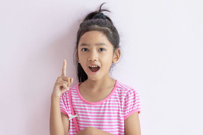 Portrait of cute girl standing against white background