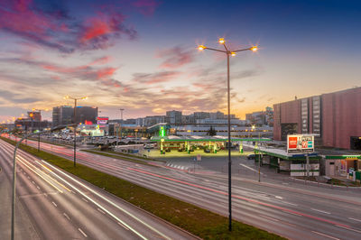 Light trails on road against sky at sunset