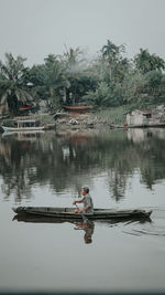 Reflection of man fishing in lake