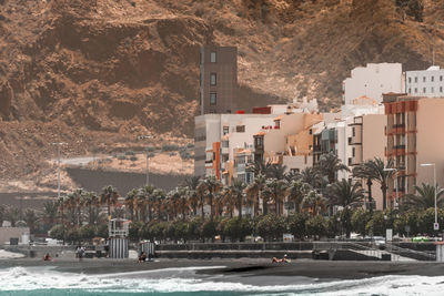 Road by buildings in city at the beach