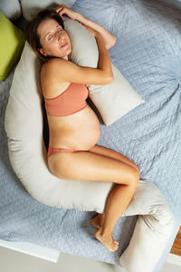 Portrait of sensuous woman lying on bed at home