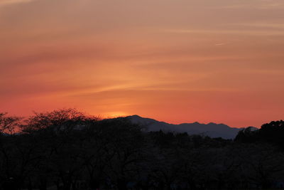 Scenic view of silhouette mountains against orange sky