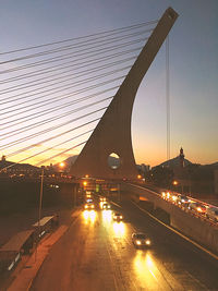 Illuminated bridge against sky at sunset