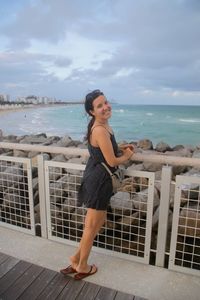 Portrait of smiling woman standing at beach