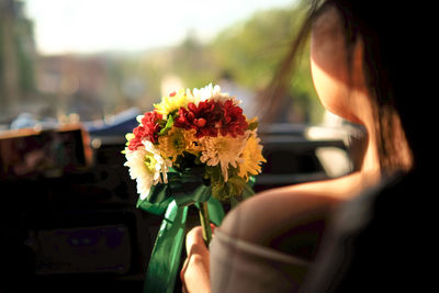 Midsection of woman holding flower