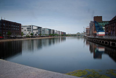 River by buildings against sky in city