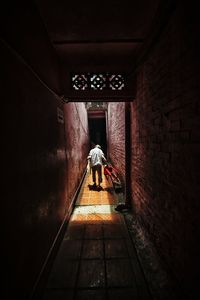 Rear view of man walking in corridor