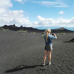 Rear view of woman photographing volcanic landscape
