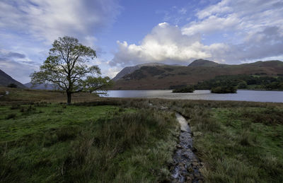 Scenic view of lake by mountain against sky