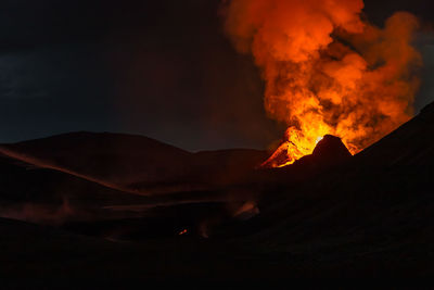 Scenic view of volcanic mountain against sky at night