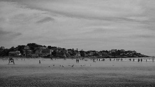 Group of people on beach against sky