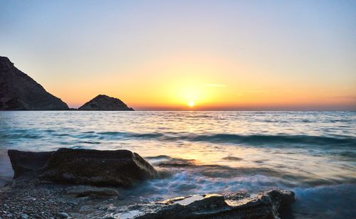 Scenic view of sea against clear sky during sunset