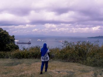 Rear view of woman looking at sea against sky