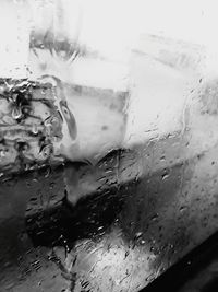 Close-up of wet window against sky