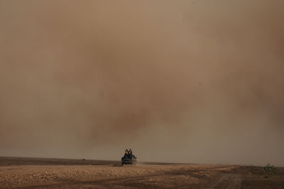 Side view of vehicle on landscape against sky