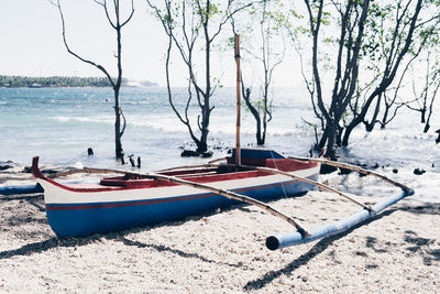 Boats moored on beach against sky