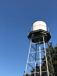 Low angle view of water tower against clear blue sky