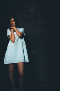 Woman looking away over black background