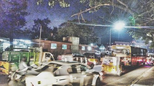 Cars on illuminated city during rainy season