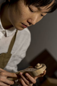 Young chinese violin maker at work in her workshop