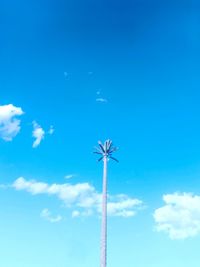 Low angle view of ferris wheel against blue sky